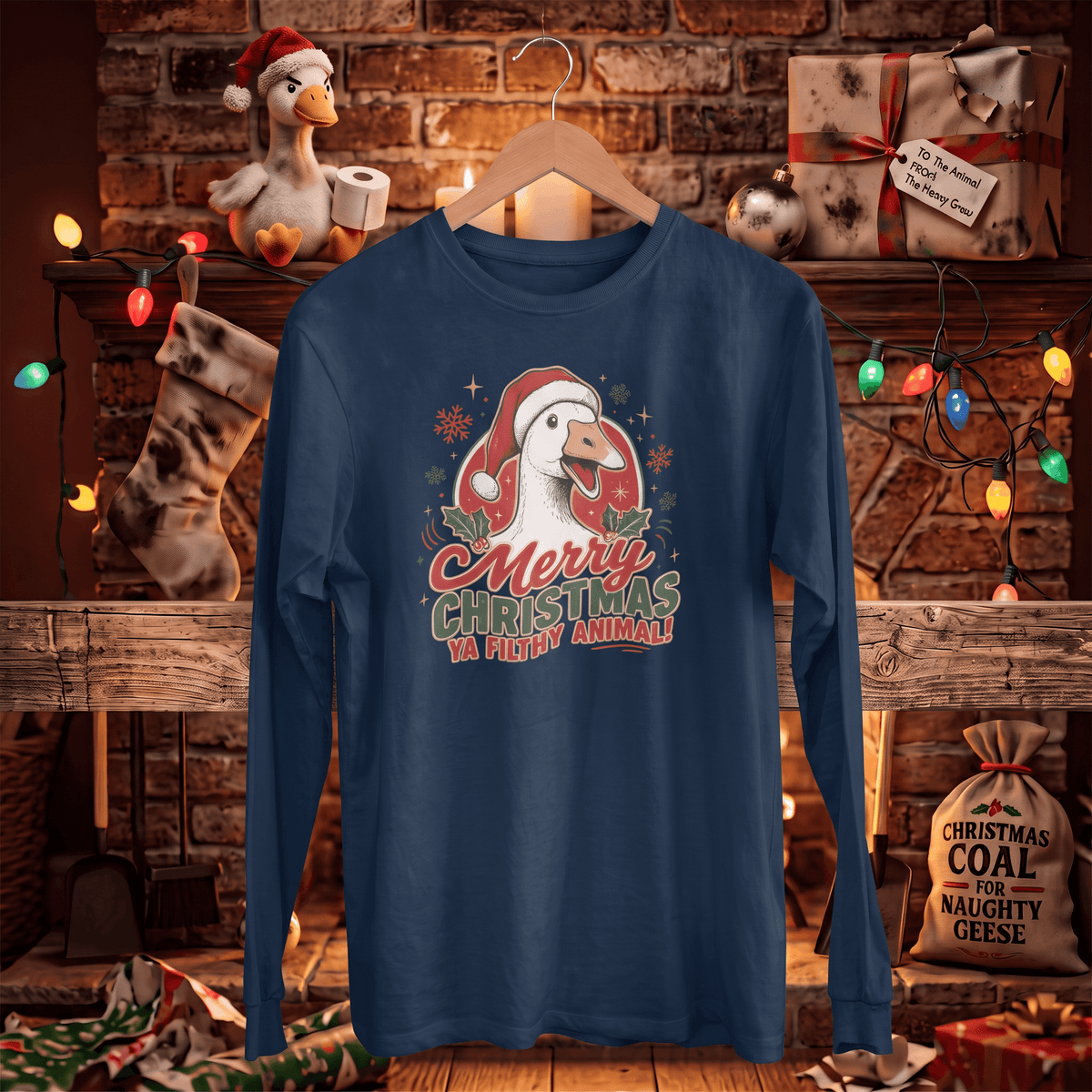 A navy blue long-sleeve t-shirt with a festive Christmas goose graphic hanging on a wooden hanger. The graphic features a goose in a Santa hat with the text 'Merry Christmas Ya Pick My Animal!'.